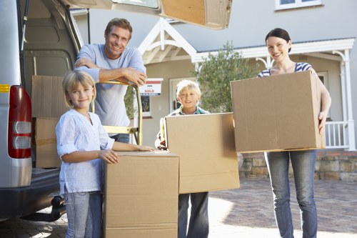 Local movers transporting furniture through a Belsize Park street